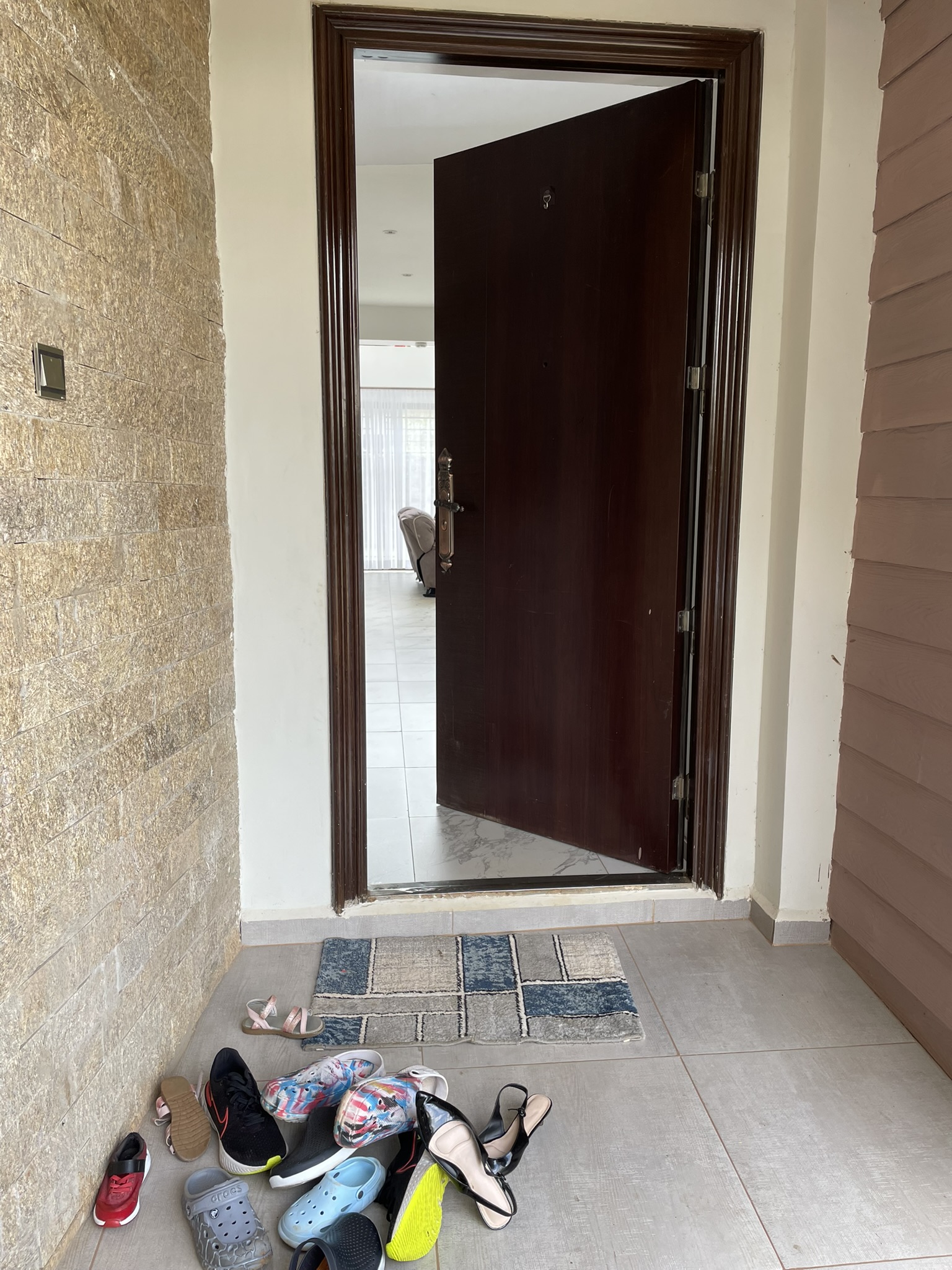 Front door approach with stone cladding and entry threshold leading into the interior lounge.